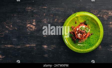 Tomaten mit getrockneten Tomaten und Fetakäse. Kalte Snacks. Auf schwarzem Holzhintergrund. Kopierbereich. Stockfoto