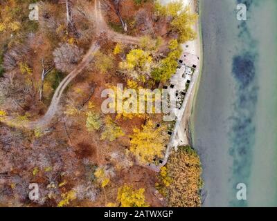 Drone Bild von heruntergekommenen verlassenen konkrete Lastkahn auf River Bank im Herbst Verfallende neben einem Fluss. Stockfoto