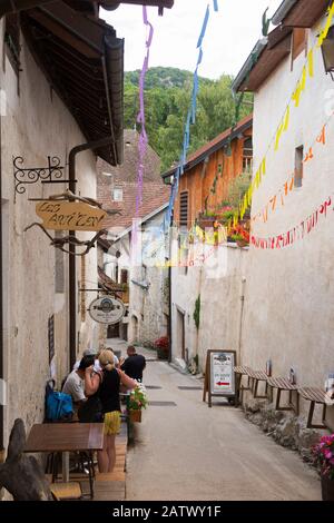 Enge Straße mit arstissanaler Brasserie/Bar/Kaffeebar auf dem Hügel in Chanaz; französische Gemeinde im Savoie-Departement in der ône Region Auvergne-<unk>-Alpen im Südosten Frankreichs. (112) Stockfoto