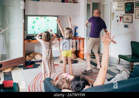Familie tanzt zusammen in einem Videospiel - gesunder Lebensstil, Zusammengehörigkeit, Spielkonzept Stockfoto