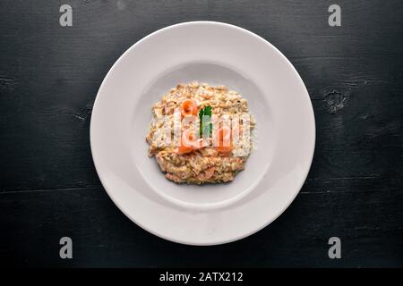 Risotto mit Lachs- und Sahnesauce. Auf Holzgrund. Draufsicht. Freier Speicherplatz. Stockfoto