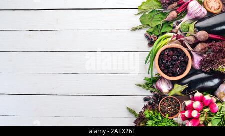 Lila Lebensmittel. Frisches Gemüse und Beeren. Auf weißem Holzhintergrund. Draufsicht. Kopierbereich. Stockfoto