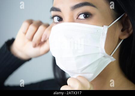 Porträt einer Frau, die eine medizinische Gesichtsmaske trägt, um die oberen Atemwege zu schützen. Stockfoto