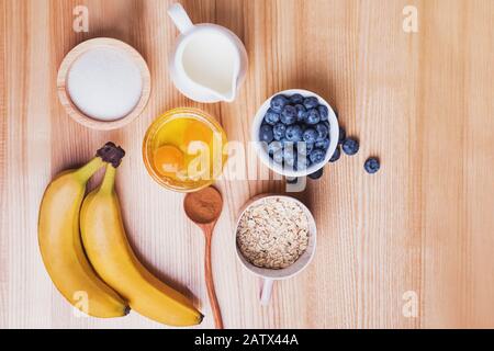 Zutaten für blueberry muffins Vorbereitung auf Holztisch, Ansicht von oben. Backvorgang. Stockfoto