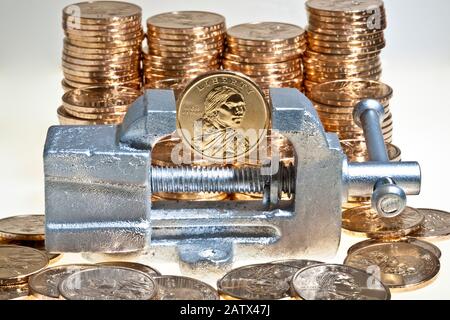 Stapel von Dollar Goldmünzen mit der Native American sacagawea Bild mit einer Münze in winzigen Silber Vice Stockfoto