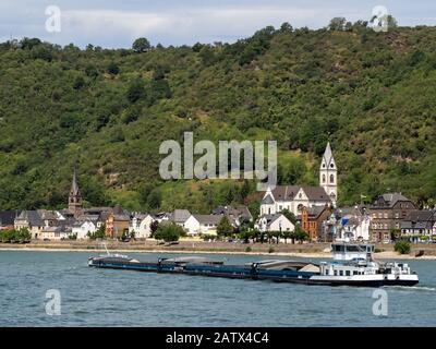 KAMP-BORNHOFEN, DEUTSCHLAND - 06. JULI 2019: Stark beladener Lastkahn, der am Rhein die Stadt Kamp-Bornhofen passiert Stockfoto