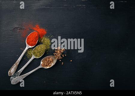 Gewürze und Kräuter. Eine große Auswahl an Gewürzen. Indische Küche. Auf dem Holztisch. Draufsicht. Freier Speicherplatz für Text. Stockfoto
