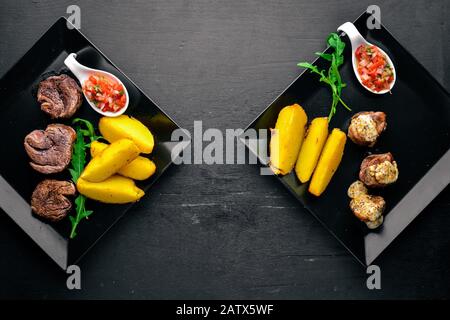 Hengste aus Schweinefleisch mit Kartoffeln auf Holzgrund. Draufsicht. Freier Speicherplatz für Text. Stockfoto