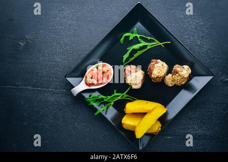 Hengste aus Schweinefleisch mit Kartoffeln auf Holzgrund. Draufsicht. Freier Speicherplatz für Text. Stockfoto