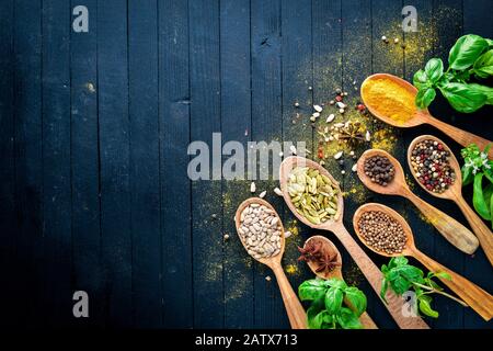 Verschiedene Gewürzlöffel auf Steintisch. Auf einem Holzbrett. Draufsicht. Freier Speicherplatz für Ihren Text. Stockfoto