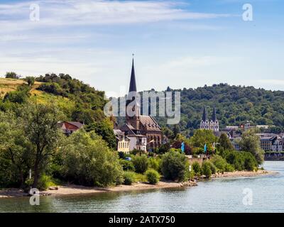 FILSEN, DEUTSCHLAND - 06. JULI 2019: St. Margaretha Kirche in Filsen am Rhein mit der Stadt Boppard im Hintergrund Stockfoto