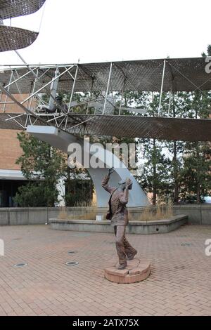 1905 Wright Flyer III Sculpture von Larry Godwin vom "ersten praktischen Flugzeug der Welt", geflogen von Wilbur/Orville, steht auf dem Boden und beobachtet. Stockfoto