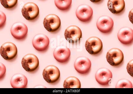 Muster von T onuts mit Pudering und Schokolade auf pastellrosa Hintergrund. Süße Donuts. Stockfoto