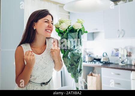 Valentinstag präsent. Fröhliche junge Frau fand Blumenstrauß aus Rosen in der Küche. Frauentag Stockfoto