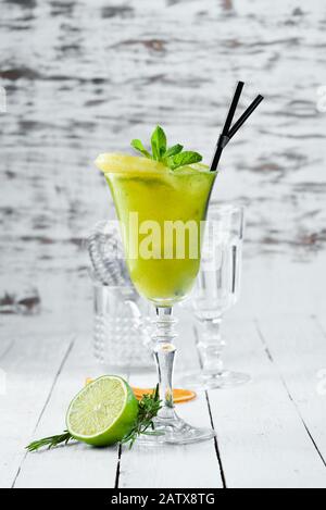 Tropisch-Grüner Alkoholischer Cocktail. Rum, Minze und Ananassaft. Alkoholischer Cocktail im Glas. Auf Holzgrund. Draufsicht. Freier Speicherplatz. Stockfoto