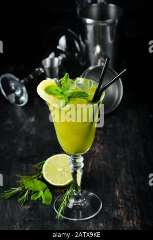 Tropisch-Grüner Alkoholischer Cocktail. Rum, Minze und Ananassaft. Alkoholischer Cocktail im Glas. Auf Holzgrund. Draufsicht. Freier Speicherplatz. Stockfoto