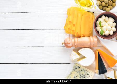 Ein großer Käsesatz. Mozzarella, Blaukäse, brie-käse, maasdam. Draufsicht. Auf weißem Holzhintergrund. Freier Speicherplatz für Ihren Text. Stockfoto
