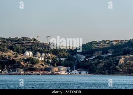 Industriesilos Tanks und Lagerung am Versandterminal neben dem Stadtgebiet am Tejo Fluss in Portugal bei Sonnenschein am Nachmittag Stockfoto