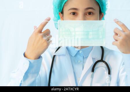 Coronavirus stoppt die Infektion. Junge Ärztin trägt Maske mit Stethoskop gegen Infektionskrankheiten und Grippe. Konzept für das Gesundheitswesen Stockfoto