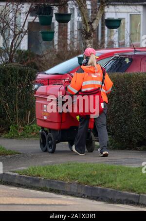 Ein Mitarbeiter von The Royal Mail sendet Post auf einer Straße in Crawley, Sussex. Stockfoto