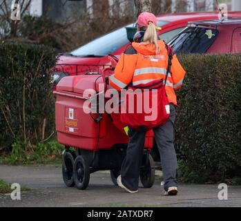 Ein Mitarbeiter von The Royal Mail sendet Post auf einer Straße in Crawley, Sussex. Stockfoto