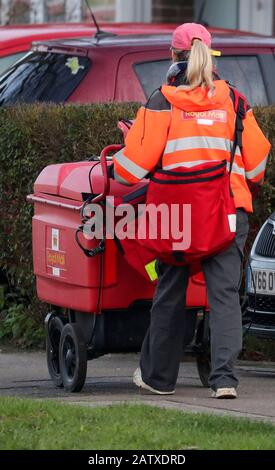 Ein Mitarbeiter von The Royal Mail sendet Post auf einer Straße in Crawley, Sussex. Stockfoto