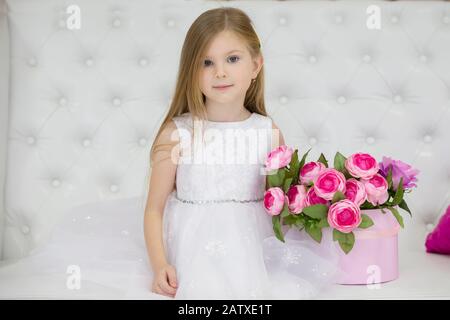 Schönes Kindermädchen mit Blumen. Stockfoto