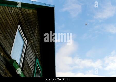 Flugzeug fliegt über dem alten Haus Stockfoto