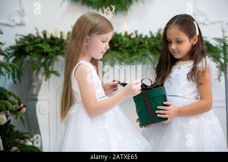 Zwei kleine Mädchen mit weihnachtsgeschenk. Kinder im neuen Jahr. Stockfoto