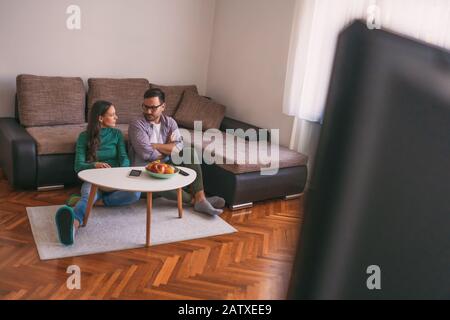 Das junge Paar sieht zu Hause fernsehen. Stockfoto