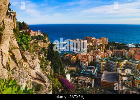 Monaco-Ville, Monaco - 28. Januar 2020: Stadtbild von Monaco, Hafen von Fontvielle und die Mittelmeerküste umrahmt von üppigen exotischen Pflanzen. Stockfoto