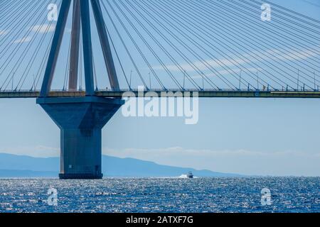 Griechenland. Bridge Rion Antirion. Hoher Pylon der Kabelbrücke über den Golf von Korinth und Motorboot bei sonnigem Wetter Stockfoto