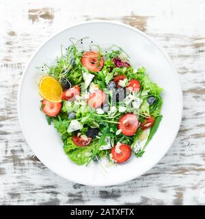 Salat. Salat aus Arugula, Blaukäse, Erdbeeren und Blaubeeren. Draufsicht. Stockfoto