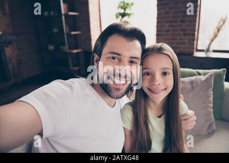 Closeup-Foto der kleinen lustigen Dame ihre schöne junge Daddy Freundschaft sitzt gemütliches Sofa, das selige Umarmungen verbringen Wochenend-Zeit-Zimmer Stockfoto