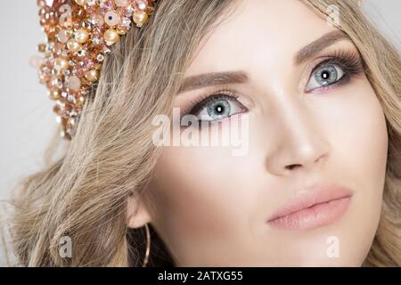 Blonde Schönheit. 3/4-closeup-Frau mit Krone, hellem Make-up der ganzen Frau, rauchenden Augen, natürlichen Farblippen. Bild für Beauty-Magazine, Zeitschriften Stockfoto