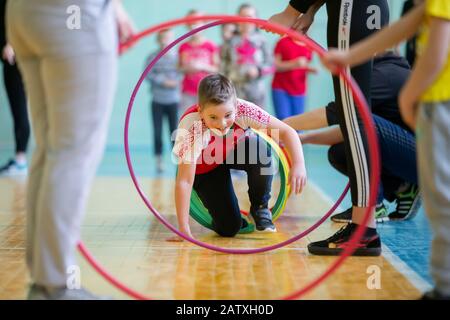 Weißrussland, die Stadt Gomil, 07. Dezember 2019. Lektion zur körperlichen Ausbildung öffnen. Der Junge nimmt an einem Sporttag Teil. Kinderstaffel. Grundschule e Stockfoto