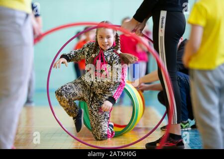Weißrussland, die Stadt Gomil, 07. Dezember 2019. Lektion zur körperlichen Ausbildung öffnen. Das Mädchen nimmt an einem Sporttag Teil. Kinderstaffel. Grundschule Stockfoto