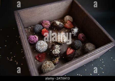 Handgemachte Obst- und Schokoladen-Bonbons in einer Holzkiste Stockfoto