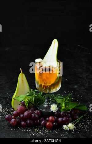 Heiße Wintergetränke. Heißer Weißwein mit Birne und Zimt. Im Glas. Draufsicht. Auf schwarzem Hintergrund. Stockfoto