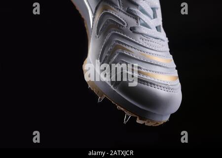 Fragment eines weißen Sneakers mit Spitzen auf schwarzem Hintergrund. Sportschuhe Stockfoto