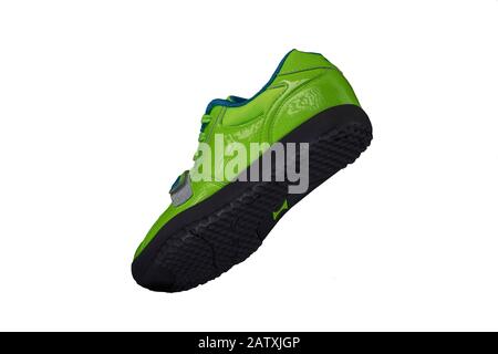 Grüner glänzender Sneaker auf weißem Hintergrund. Sportschuhe Stockfoto