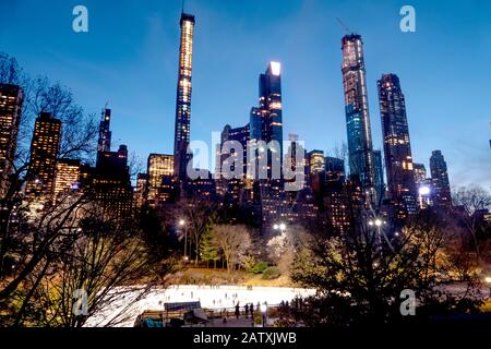 Die atemberaubende Skyline und die Eisbahn Central Park von Midtown Manhattan Island, New York City, Vereinigte Staaten von Amerika. Stockfoto