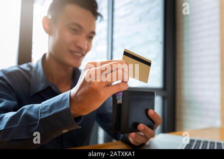 Geschäftsmann mit Kreditkarte. Zahlung beim Online-Shopping. E-Commerce und modernes Technologiekonzept Stockfoto