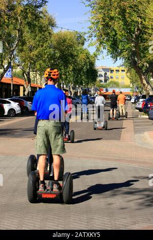 Touristen, die eine Besichtigungstour auf Segways in Der Altstadt von Scottsdale AZ genießen Stockfoto