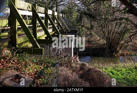 Eine Fußgängerbrücke, die den Fernweg Weavers Way über den ehemaligen Nord-Walsham- und Dilham-Kanal bei Honing, Norfolk, England, Großbritannien, Europa führt. Stockfoto