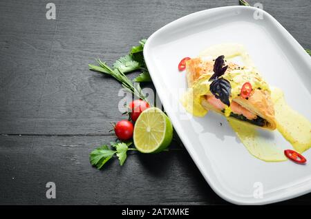 Gebackener Lachs mit Spinat im Teig. In der Platte. Draufsicht. Freier Speicherplatz für Ihren Text. Stockfoto
