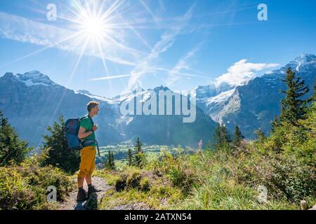 Wanderer auf dem Wanderweg nach Bachalpsee, hinter schneebedeckten Schreckhorn, Wetterhorn und Eiger, Grindelwald, Bern, Schweiz Stockfoto