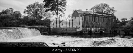 Das Wasserkraftwerk aus den 1920er Jahren auf seiner Insel neben dem Wehr in Linton Lock, Yorkshire, Großbritannien. Stockfoto