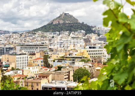Malerische Aussicht auf Athen und den Lycabettus vom Akropolishang, Griechenland. Panorama von Athen von oben im Sommer. Über die Stadt erhebt sich ein felsiger Hügel. Stockfoto