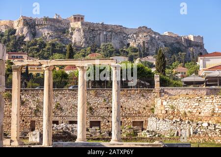 Sonniger Blick auf die Bibliothek von Hadrian mit Blick auf Akropolis, Athen, Griechenland. Der berühmte Akropolishügel ist das wichtigste Wahrzeichen Athens. Landschaft von Athen ce Stockfoto